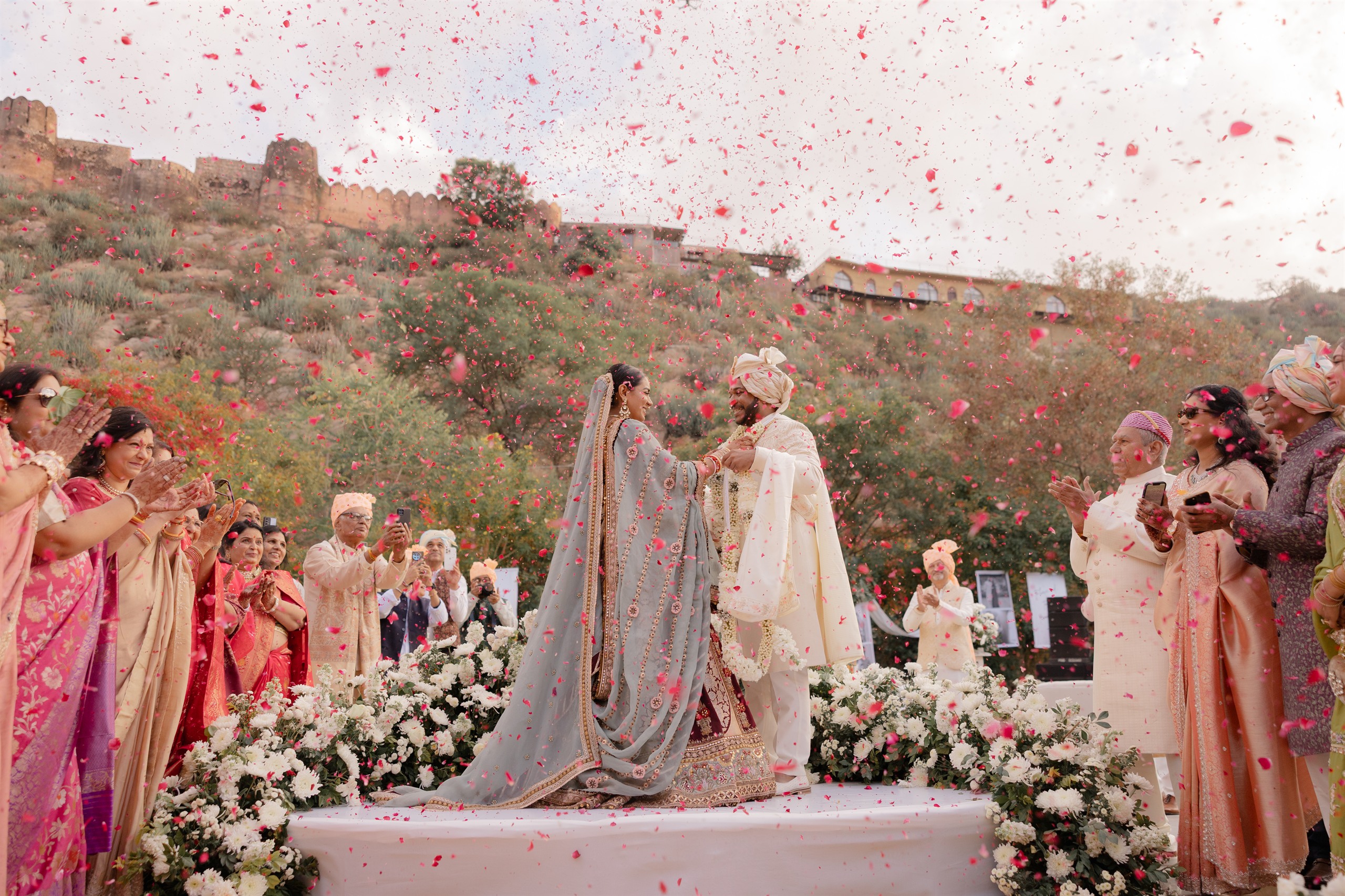 Rose petals shower the couple at the varmala — Anupama & Abhinav, Mundota Palace, Jaipur