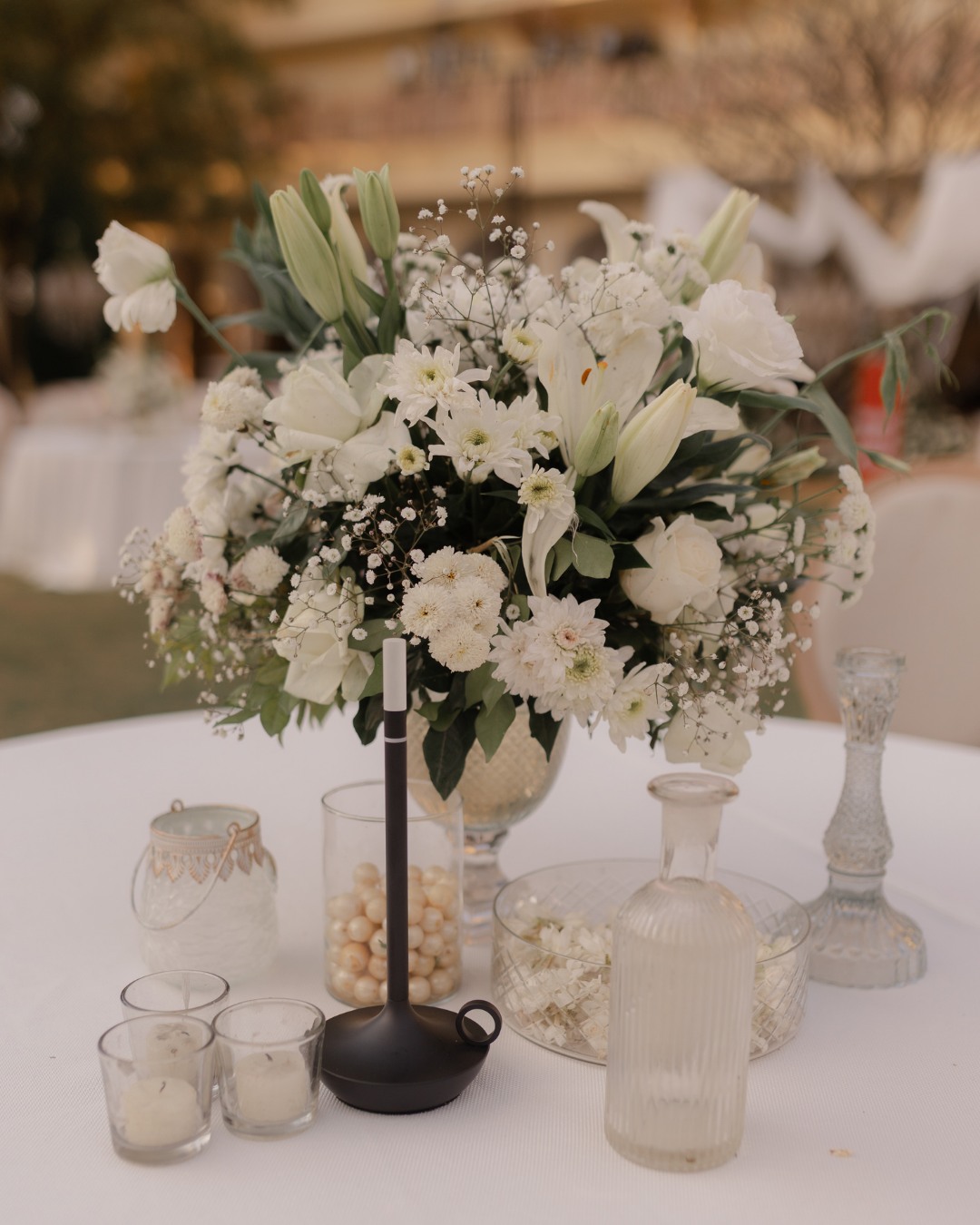 White florals and glassware set on a guest table — Anupama & Abhinav, Mundota Palace, Jaipur