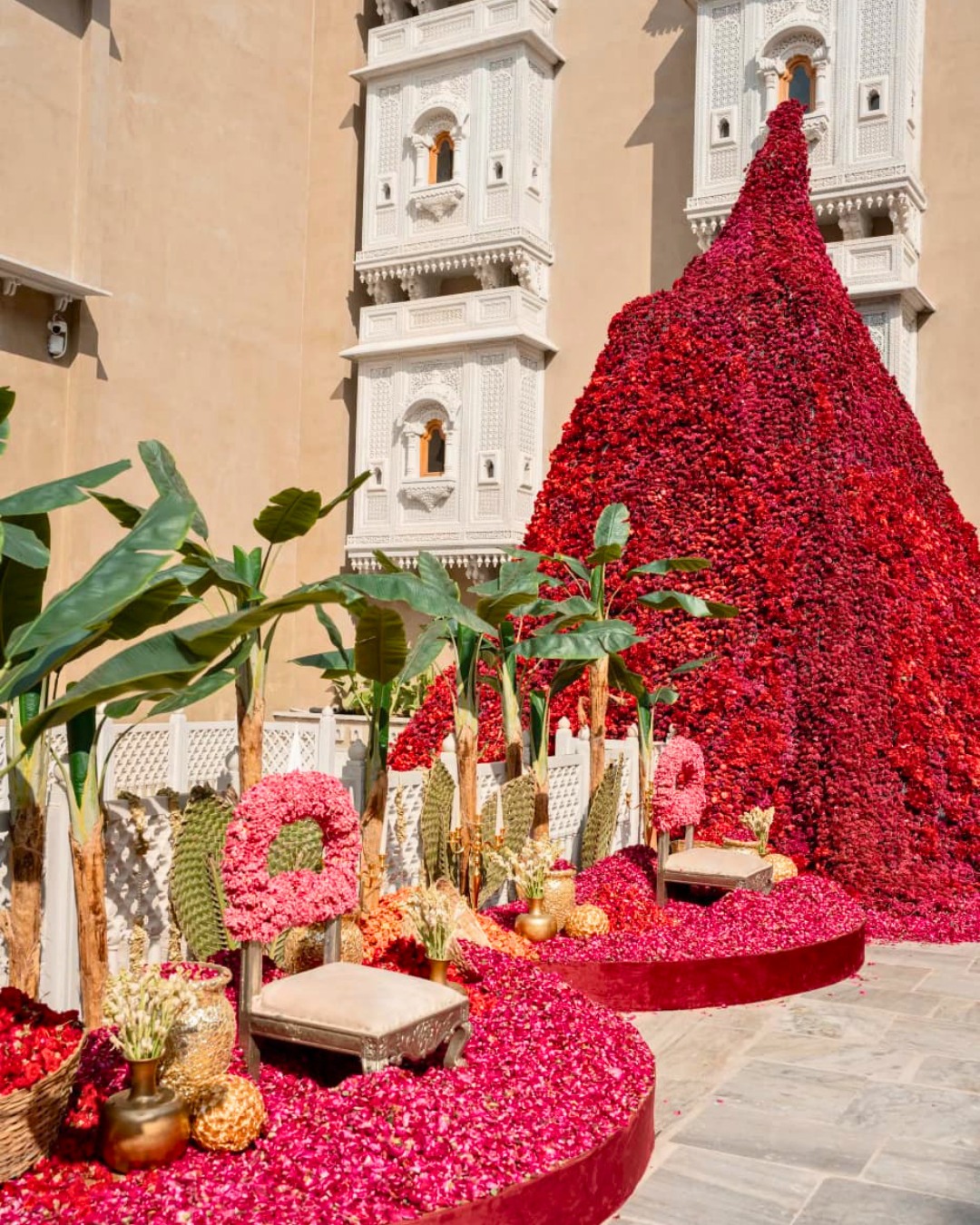 Crimson floral pyramid in the palace courtyard — Devanshi & Rohan, Taj Lalit Bagh, Udaipur