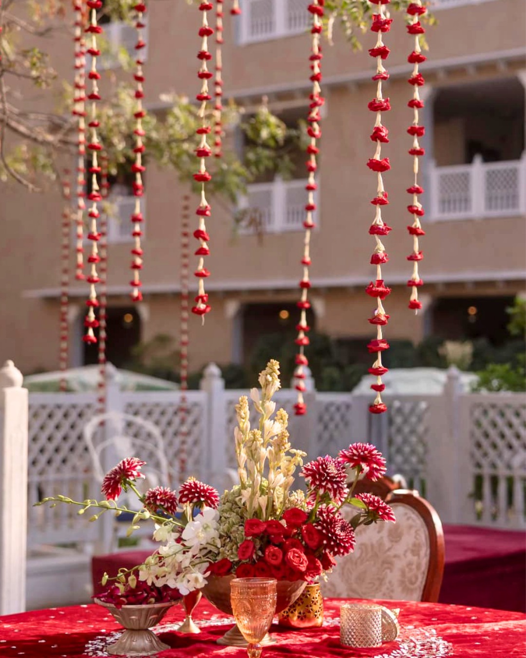 Gold vases, red florals and a welcome sign at the haldi entrance — Devanshi & Rohan, Taj Lalit Bagh, Udaipur