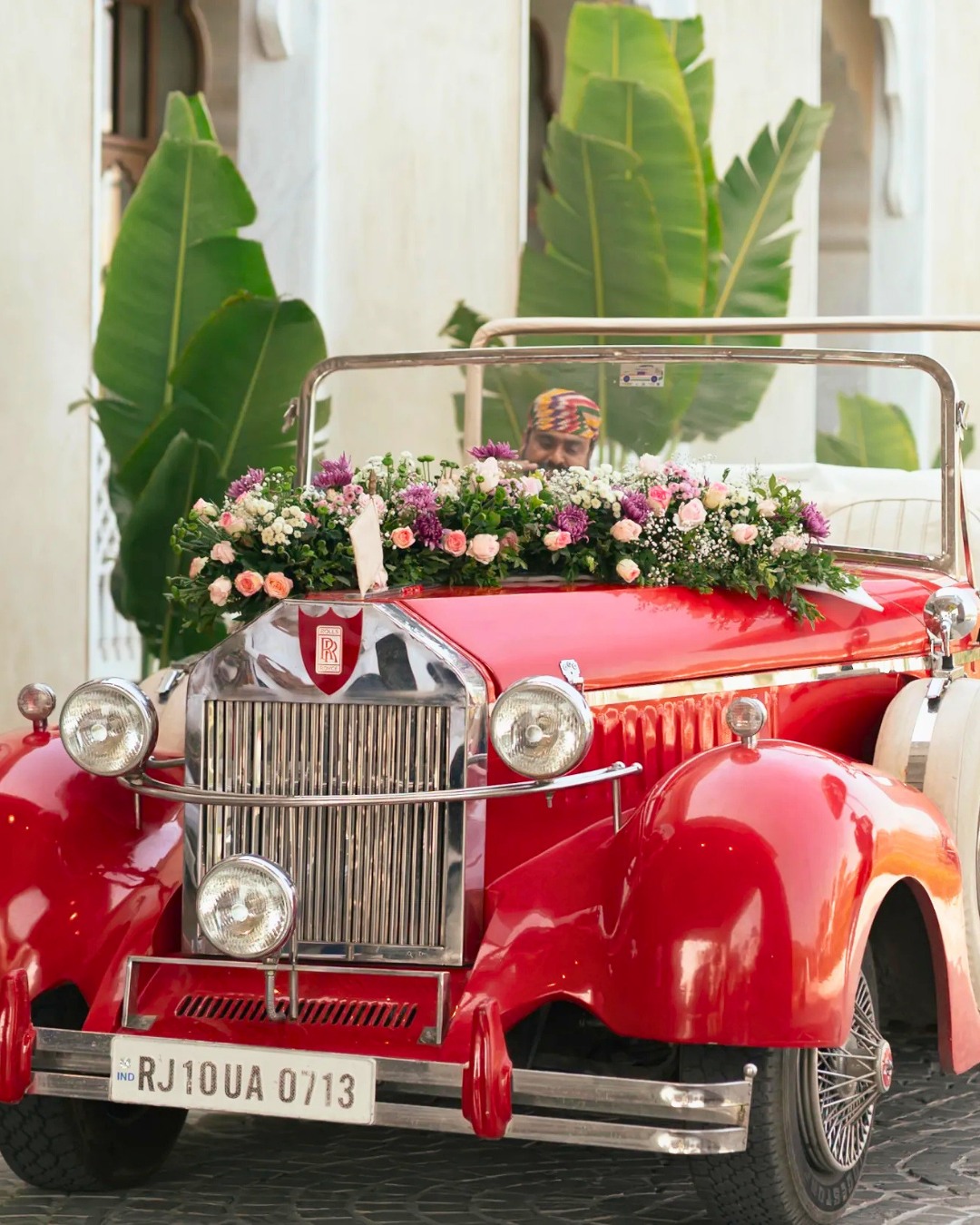 A red vintage car decorated with florals — Devanshi & Rohan, Taj Lalit Bagh, Udaipur